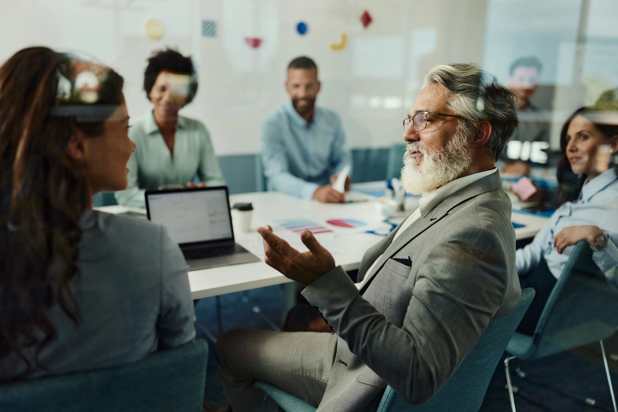 Senior consultant speaking with a colleague during a strategy meeting